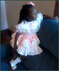 Lifetime adoptee Bethany standing on a sofa in a frilly pink dress