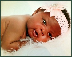 Portrait of a black baby girl in a pink floral headband
