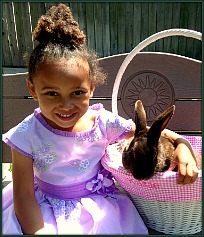 Little girl with Easter dress holding bunny in basket