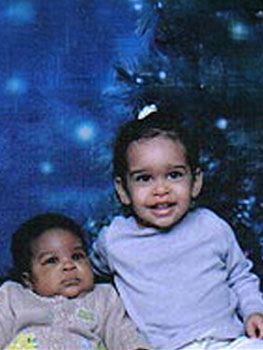 African American baby and big sister looking at camera