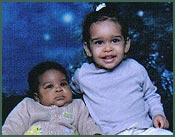 African American baby and big sister looking at camera