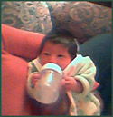 Dave and Dawn's small newborn baby drinking a bottle of milk