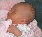 Sleeping newborn baby girl wrapped in pink