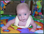 Baby girl crawling on a play mat