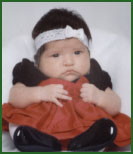 Jackey and Vicki's adopted infant daughter in a Christmas dress