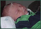 Sleeping newborn baby boy in a striped polo shirt