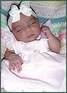 sleeping baby in dress with bow