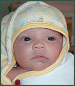 newborn snuggled in towel with hood