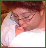 Adoptive mother Melanie kisses her newborn baby