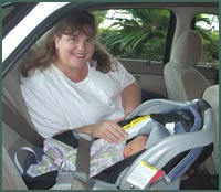 Mom buckling baby into car seat