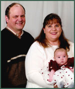 Portrait of adoptive parents Terry and Brenda with their infant daughter
