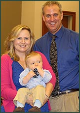 newly adopted baby and new adoptive parents pose for photo