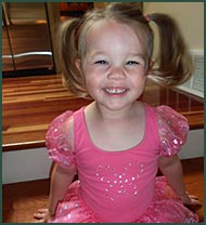 Smiling little girl in a pink dance costume