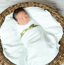 Lifetime adoptive parents Corey and Joann's new baby in a basket