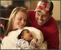 David and Chantel smiling down at adopted baby