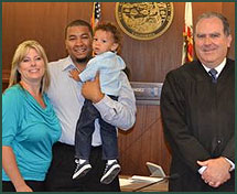 Doug, Bridget, and their son pose next to the judge at adoption finalization