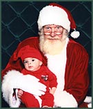 baby dressed in read visits Santa Claus