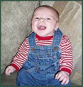 Laughing baby boy in overalls