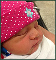 Close up of a baby girl in a polka dotted hat