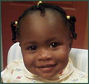 Smiling African American baby girl in pigtails