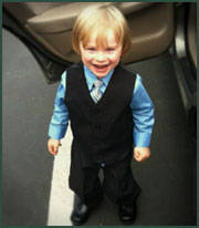 Blond little boy dressed up in a vest and tie