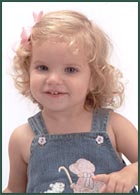 Portrait of a little blond girl in overalls