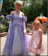 Child in pink dress holding hands with Cinderella