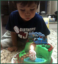 Adopted 3-year-old son blowing out birthday cake candle