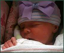 Sleeping baby with purple bow