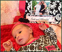 baby lying next to photo of newly adopted parents