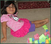 Little girl sitting on the floor playing with blocks