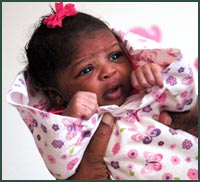 Newborn baby girl in pink bow and floral blanket