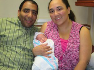 Adoptive couple holding baby in hospital