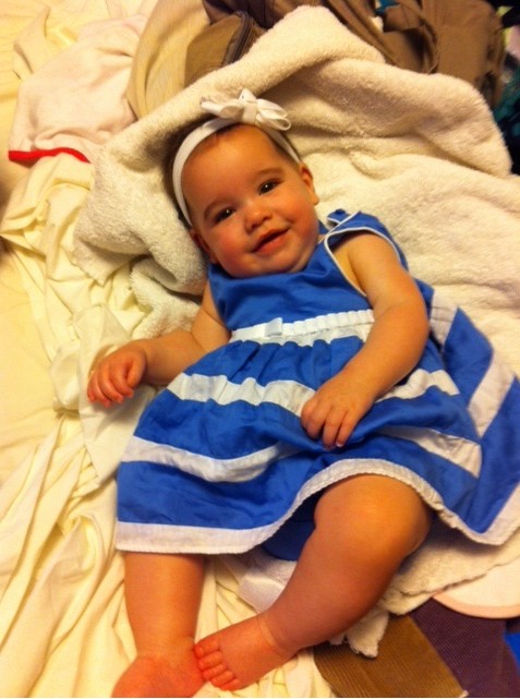Caucasian baby girl in a blue and white striped dress