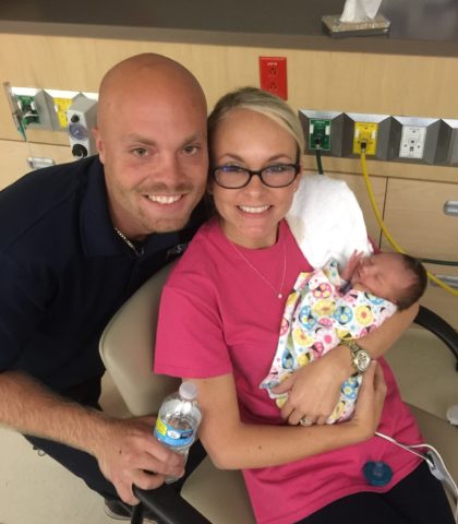 Adoptive parents in hospital holding baby in blanket