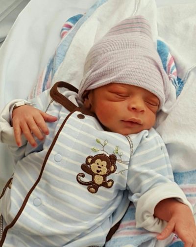 Newborn baby boy in a monkey sleeper