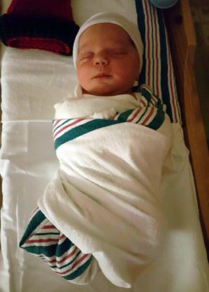 Newly-born baby swaddled in hospital blanket
