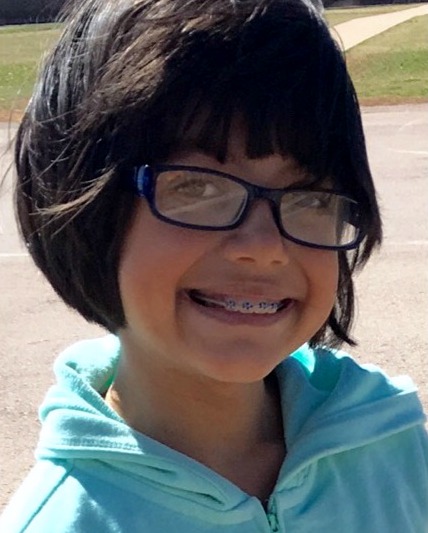 Grade school age girl wearing braces and glasses