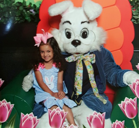 Young girl poses with a giant Easter bunny