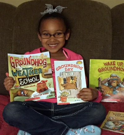 young girl shows off her collection of Groundhog Day books