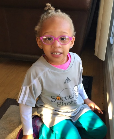 Girl in soccer shirt and pink glasses