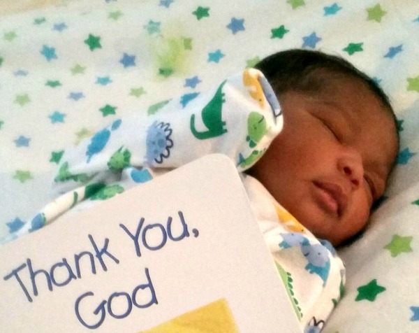 Thank You God sign near adopted newborn
