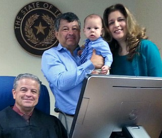 Juan and Maricela with adopted baby wearing a tie and judge