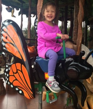 Little girl riding a butterfly on a merry-go-round