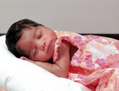 Sleeping baby girl in a peach floral dress