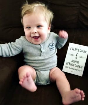 Happy baby Gage with a sign reading 6 months