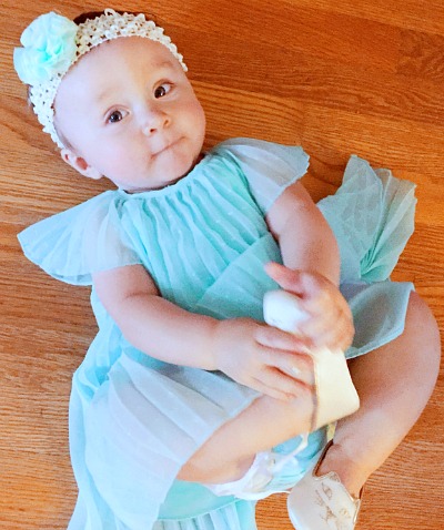 Baby girl in an Easter dress lying on the floor