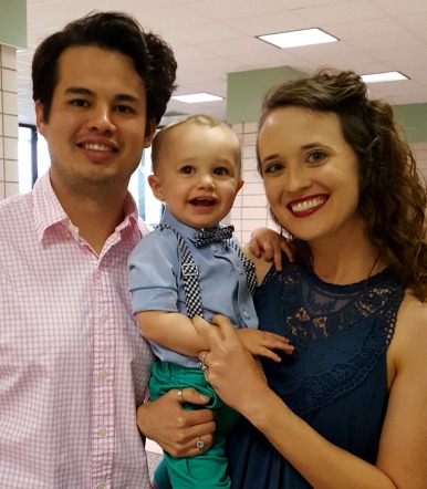 Smiling couple with their baby boy in a bowtie