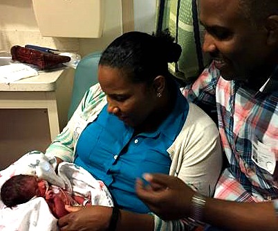 Adoptive parents look at baby in hospital