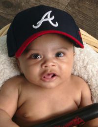 Baby with Atlanta Braves baseball cap on